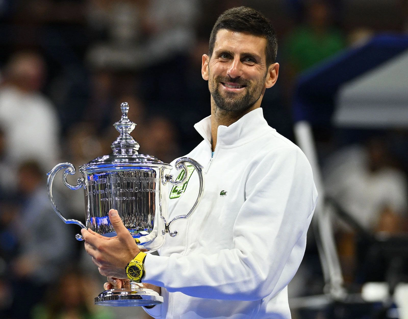 Novak Djokovic holding the US Open trophy and smiling