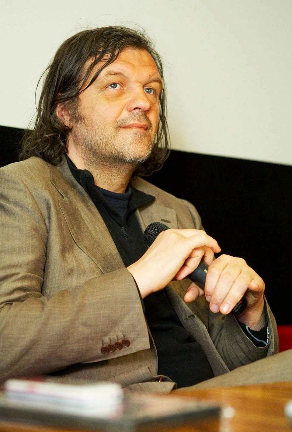 Emir Kusturica speaking into a microphone at an event