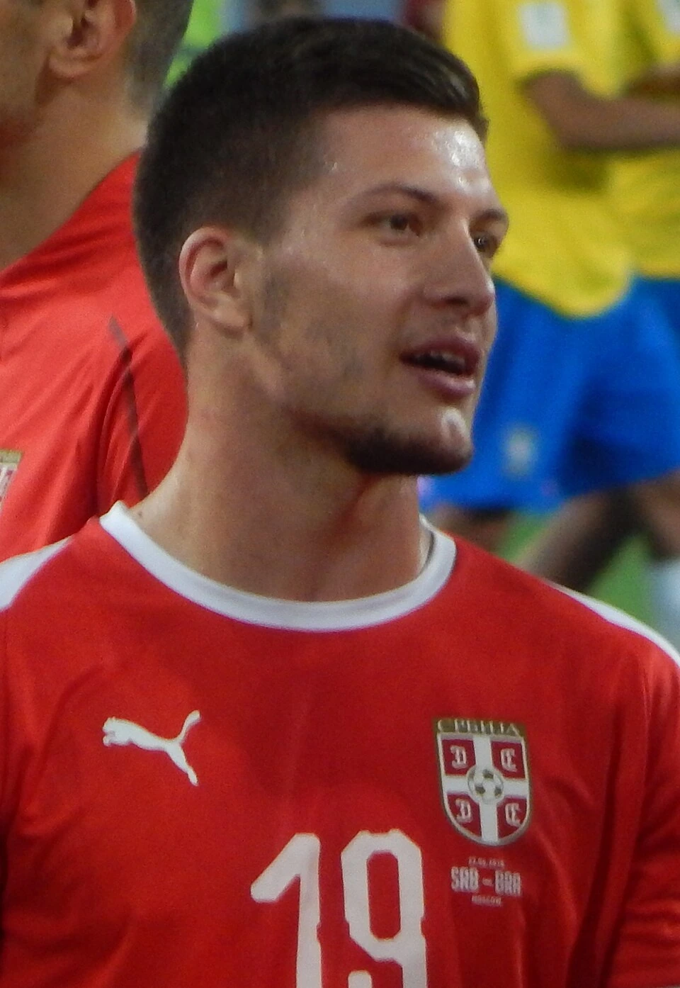 Serbian footballer Luka Jović in a match, wearing a red Serbia jersey.